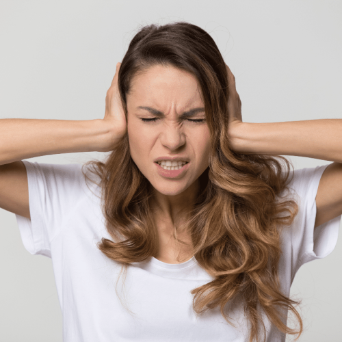 femme irritée qui se bouche les oreilles