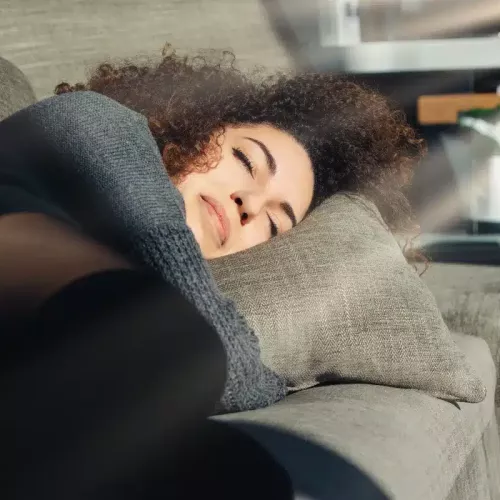 Une jeune femme faisant la sieste sur le canapé